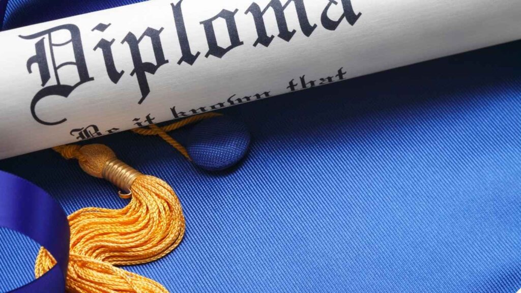  Rolled diploma certificate with gold tassel on a blue graduation gown